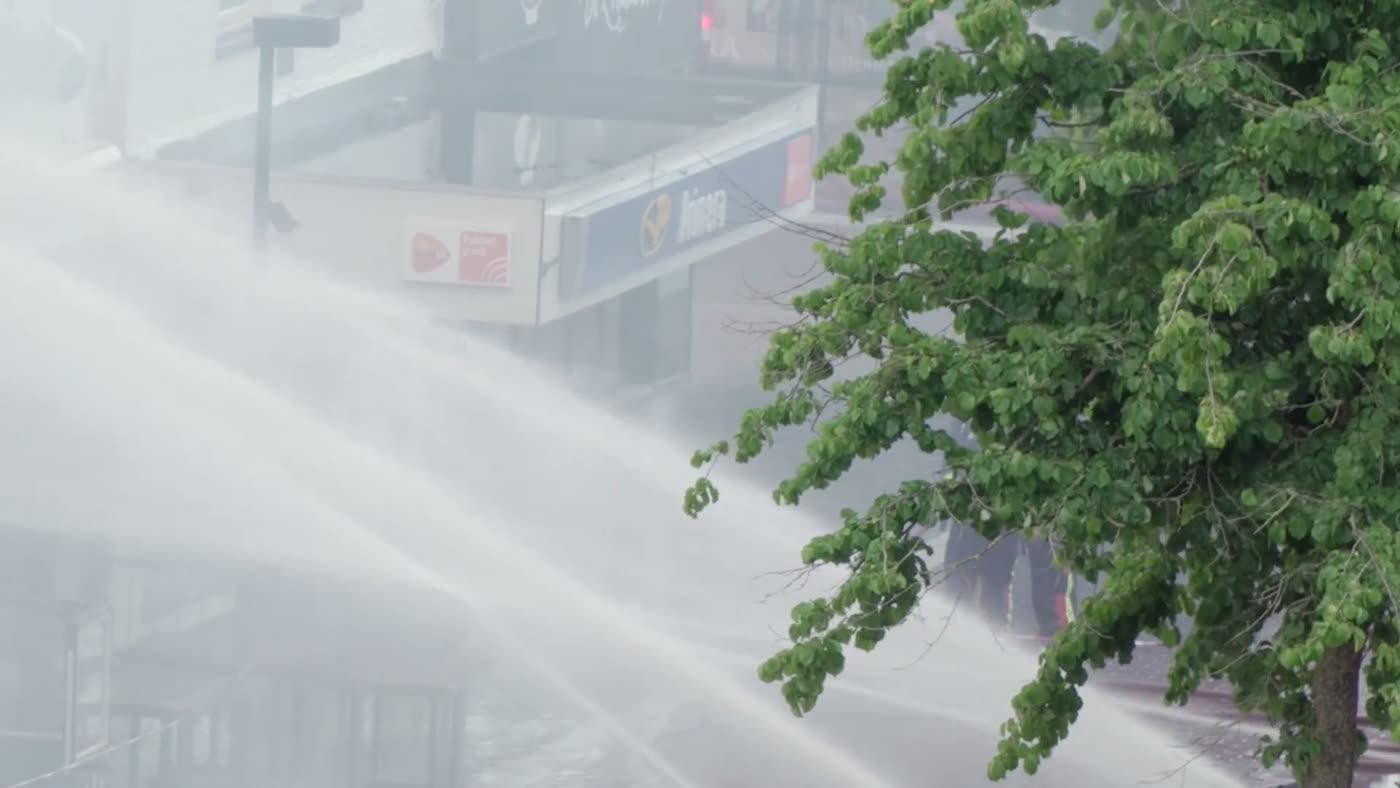 High-pressure water spray arcing across a street